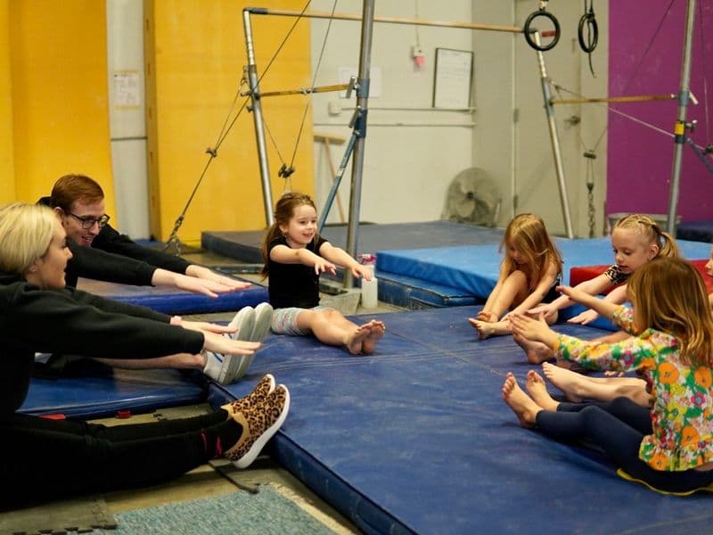 Kinderen rekken samen op de mat